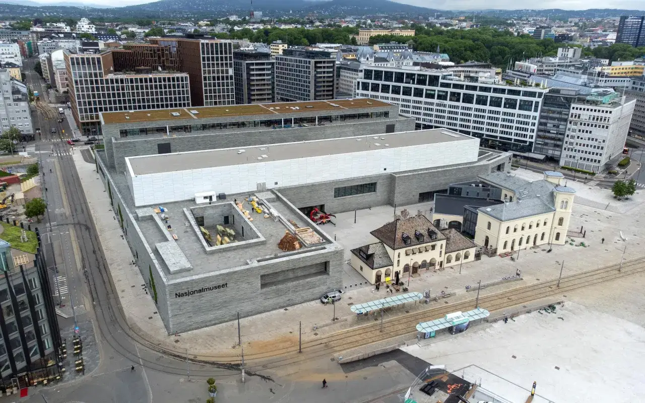 Vy över Nasjonalmuseet i Oslo med omgivande byggnader och spårväg.