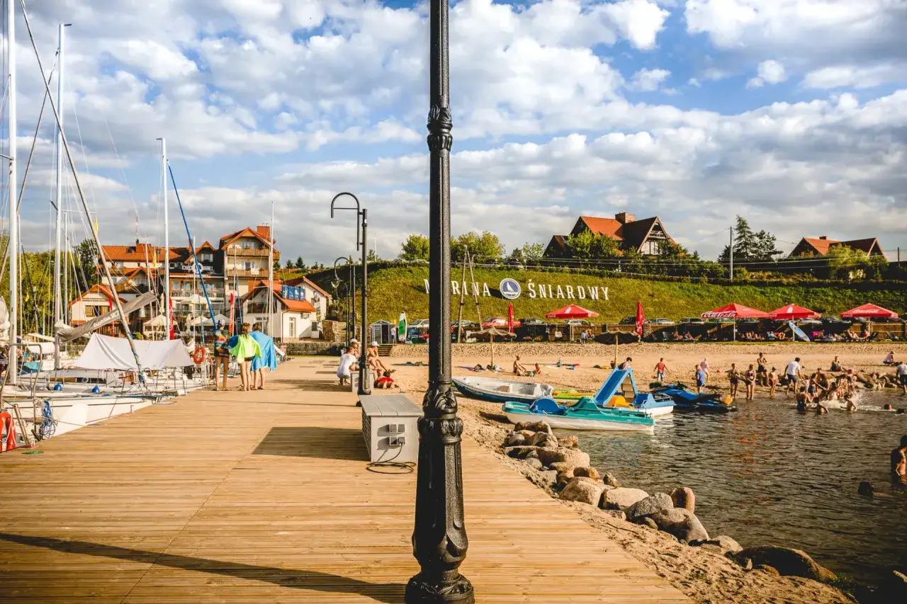 Ludzie odpoczywają na plaży nad jeziorem Śniardwy, które jest największym jeziorem w Polsce.