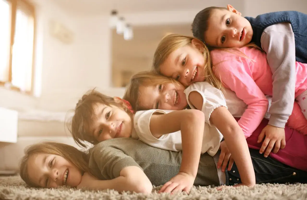 Bambini in pila, sorrisi e risate, ognuno con le sue espressioni uniche. Le differenze tra figli emergono nella loro gioia condivisa.