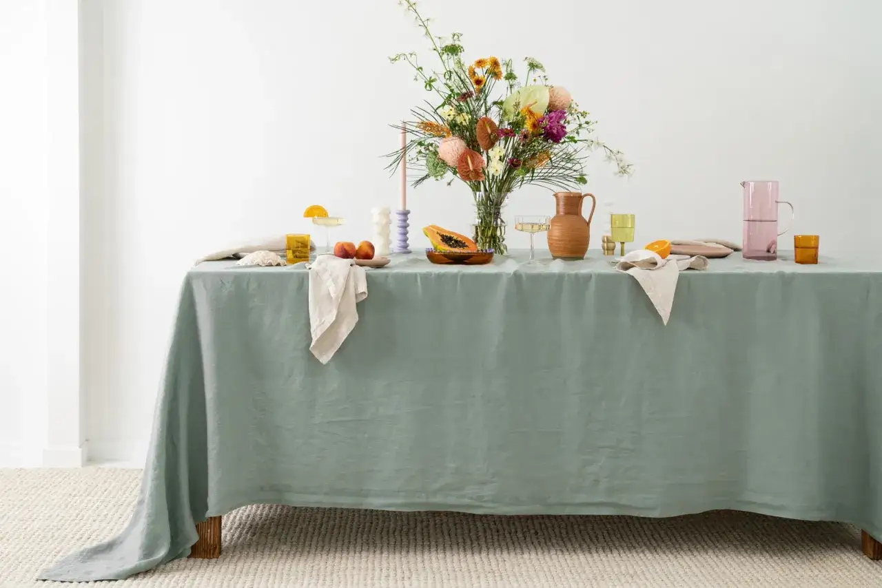 Enkel dukning med en vacker blomsterbukett, frukt och glas.
