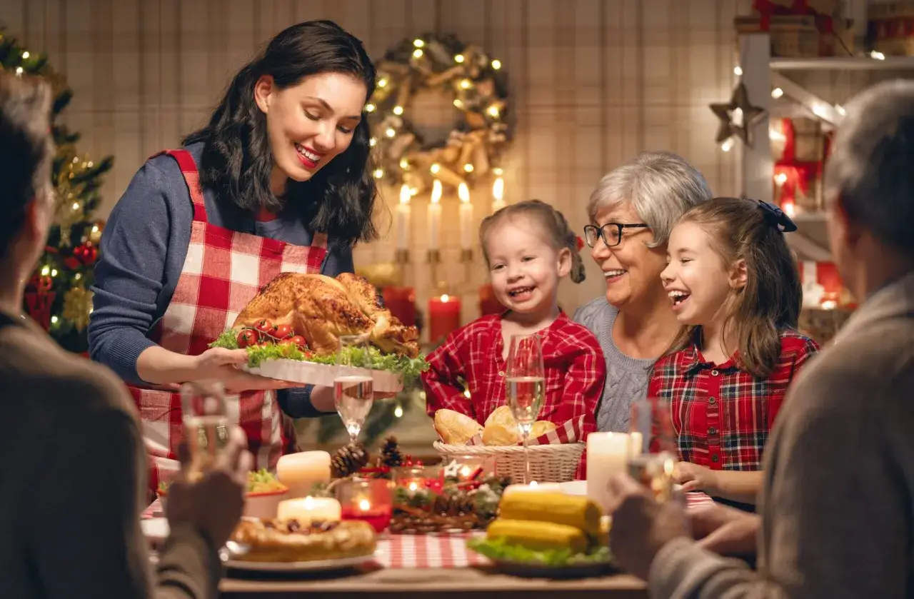 Familie feiert Weihnachten mit Truthahn und Kerzenlicht. Die Freude zeigt, was man an Weihnachten feiert: Gemeinschaft und Dankbarkeit.