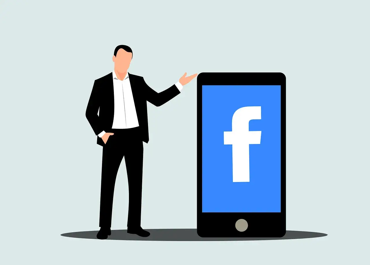Mężczyzna w garniturze prezentuje smartfon z logo Facebooka. Dowiedz się, jak usunąć rolki z Facebooka, aby uporządkować sw&oacute;j profil.