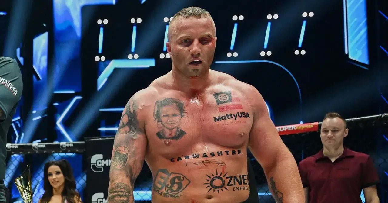 Bokser z tatuażami na klatce piersiowej, w tym portret dziecka i flaga, po walce. W tle widać światła i ring. Wyniki walki Fame MMA.