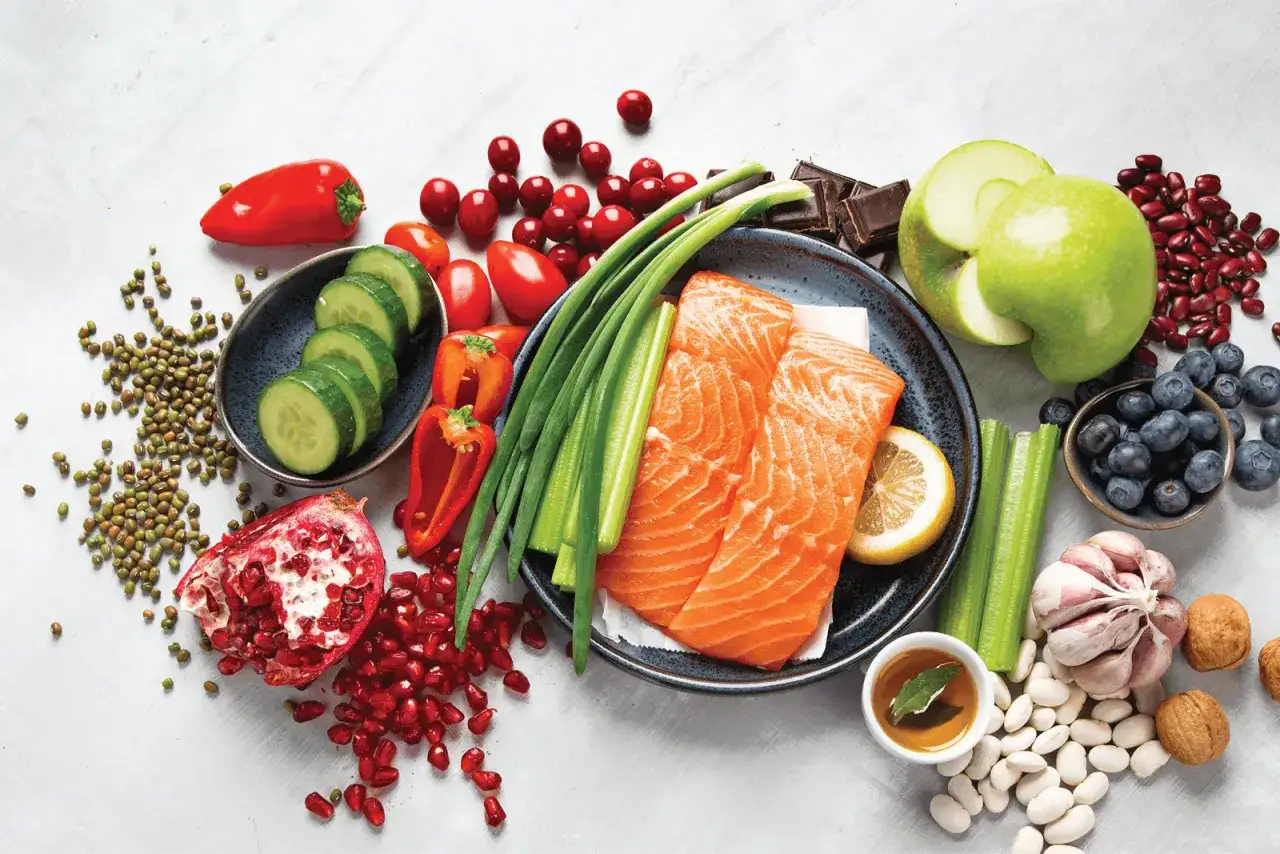 Salmone, mirtilli, noci e altri 12 alimenti che fanno bene al cervello e alla memoria, disposti su uno sfondo chiaro.