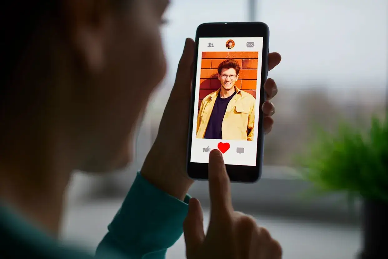 Szukasz odpowiedzi, jak znaleźć kogoś na Tinderze? Na ekranie telefonu widzisz profil mężczyzny z serduszkiem, gotowy do polubienia.