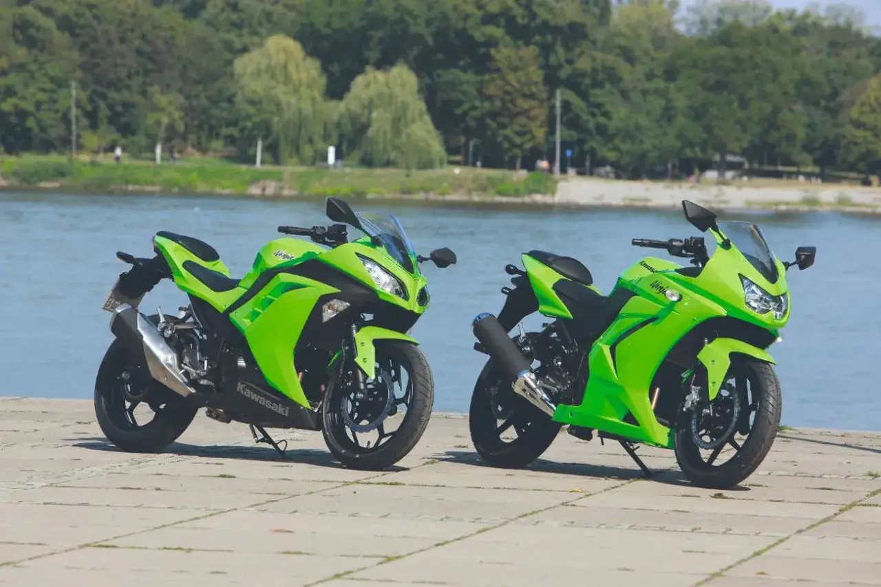 Dwa zielone motocykle Kawasaki Ninja 250 stoją nad wodą. Idealne do miasta i na weekendowe wypady, poznaj ich kawasaki ninja 250 dane techniczne.