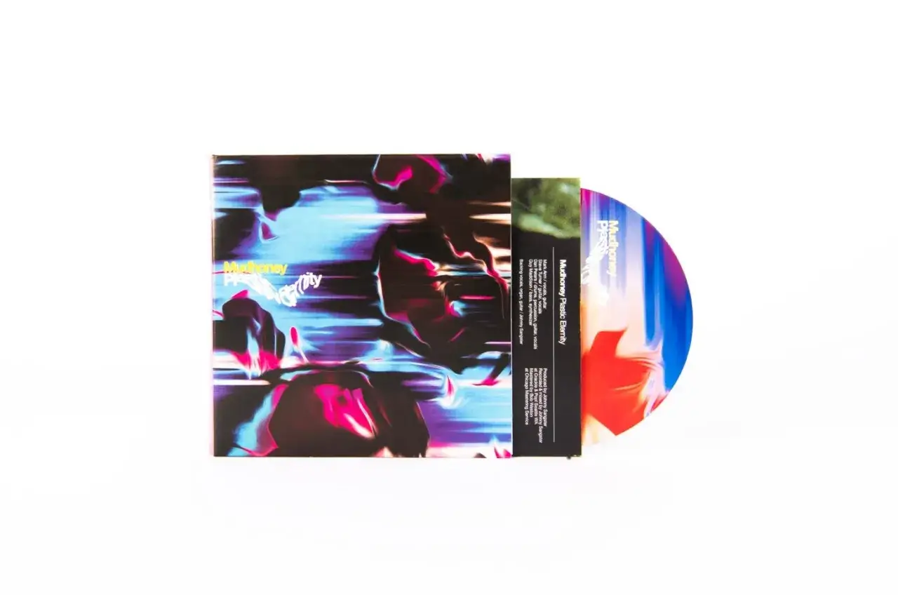 Mudhoney - Plastic Eternity, pamiątka z mojej podróży. Okładka płyty CD z psychodelicznym, rozmytym wzorem w kolorach niebieskim, różowym i czarnym.
