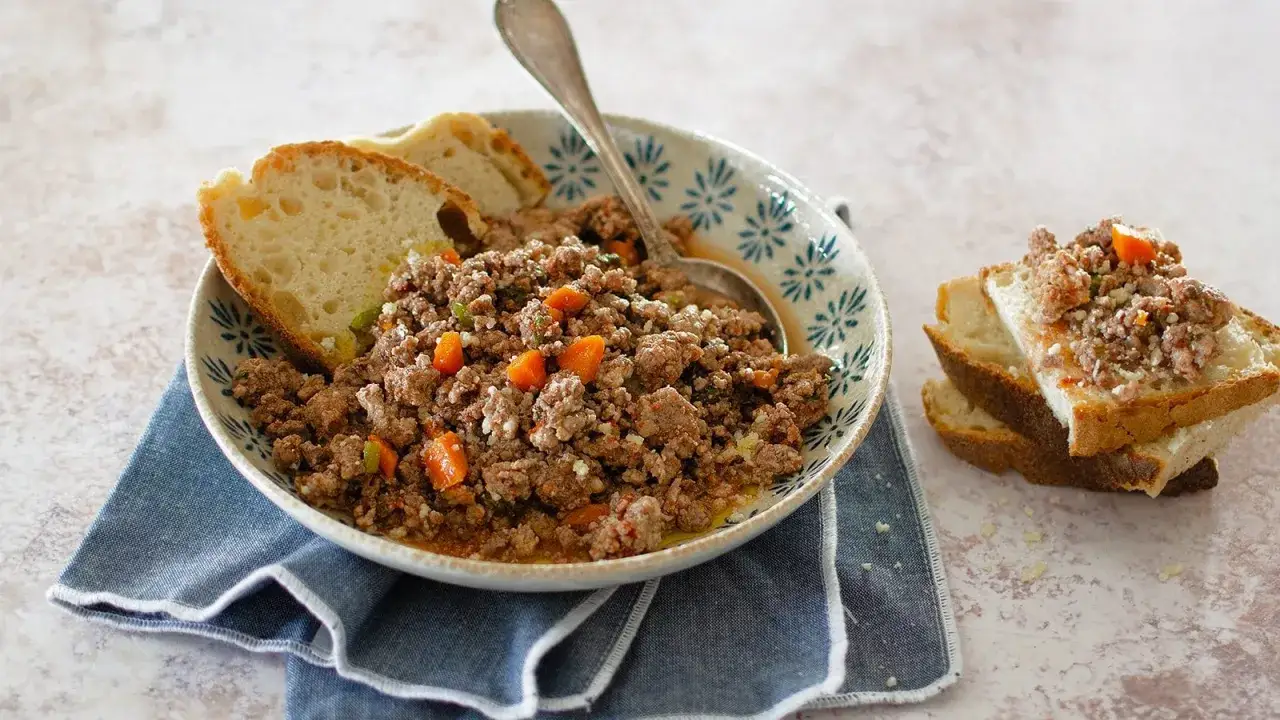 Un piatto invitante di carne macinata con verdure, perfetto per gustose ricette con carne macinata, servito con pane tostato.