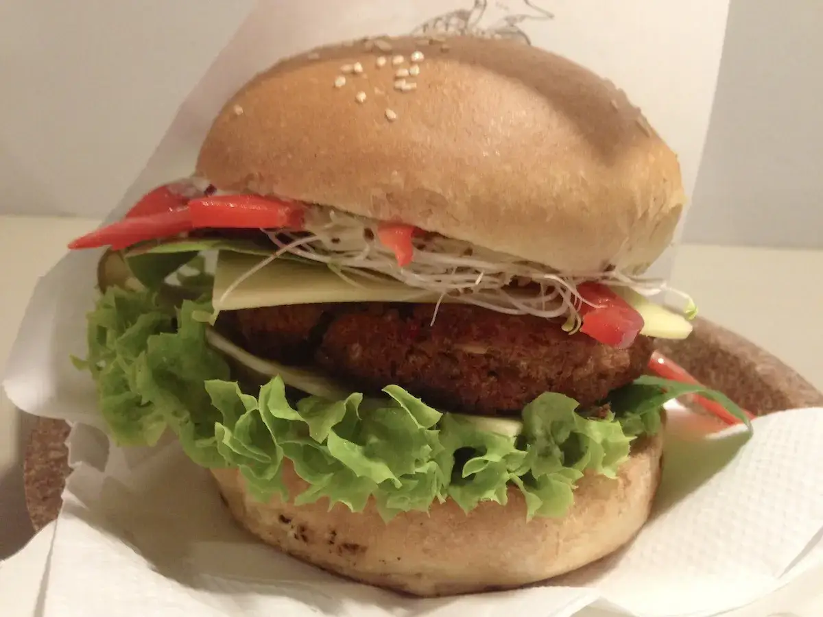 Pyszny wegański burger z kotletem, serem, sałatą, kiełkami i pomidorem. Prawdziwa krowarzywa uczta dla podniebienia!