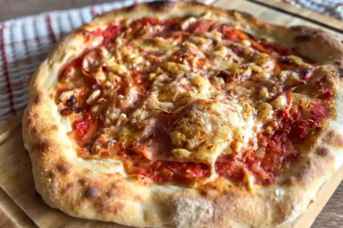 Pyszna pizza napoletana z rozpływającym się serem i sosem pomidorowym, pachnąca włoskimi wakacjami.
