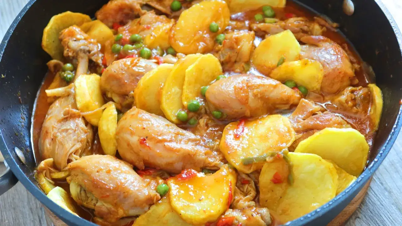 Pollo guisado con patatas, guisantes y pimientos. Un plato casero perfecto para tus recetas con pollo.