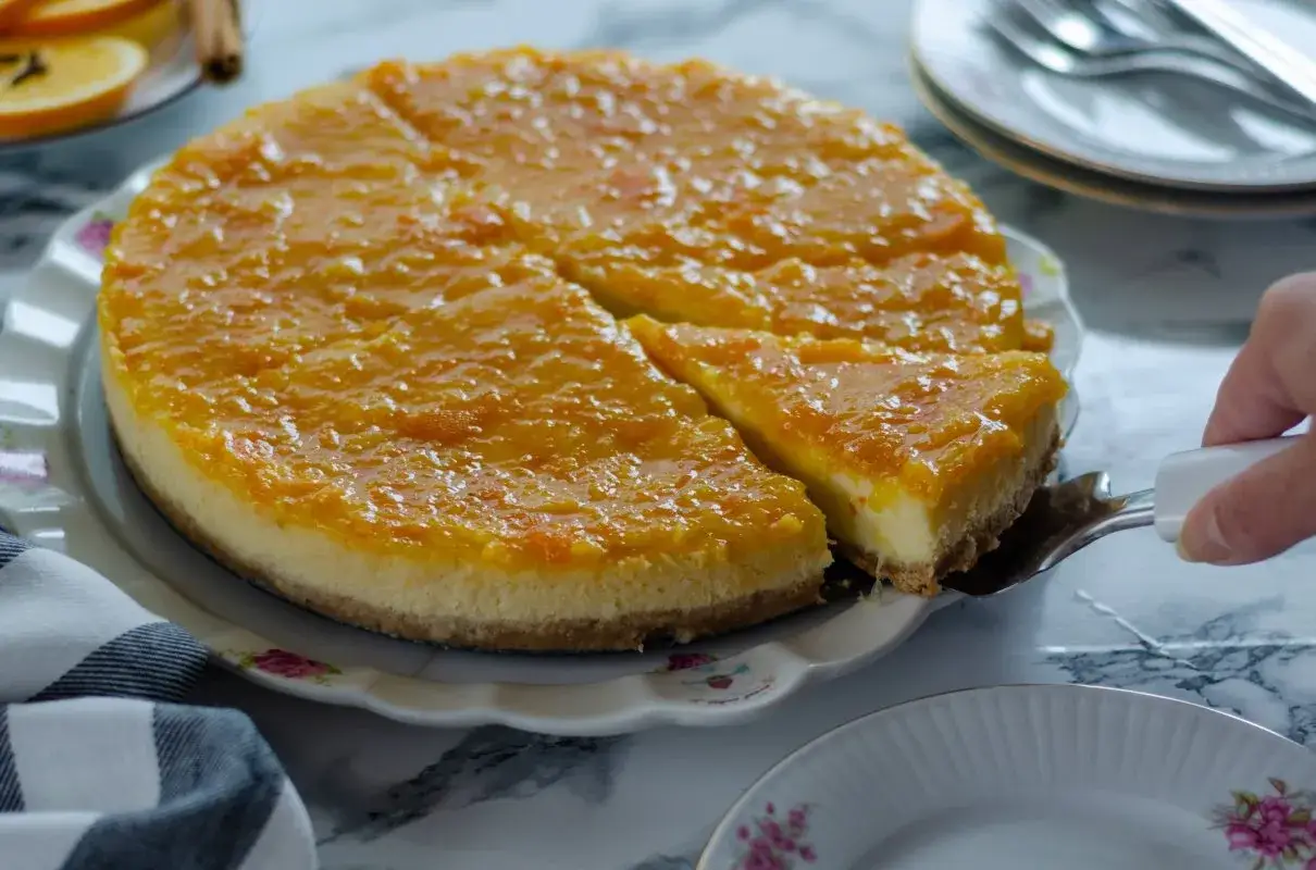 Pyszny sernik pomarańczowy z mascarpone, z błyszczącą, pomarańczową polewą. Krojenie kawałka tego ciasta to czysta przyjemność.