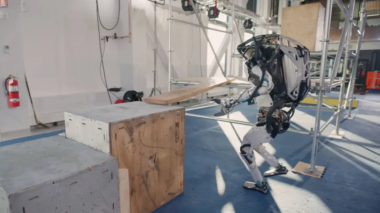 Zaawansowane roboty humanoidalne ćwiczą pokonywanie przeszkód, w tym drewnianej deski.