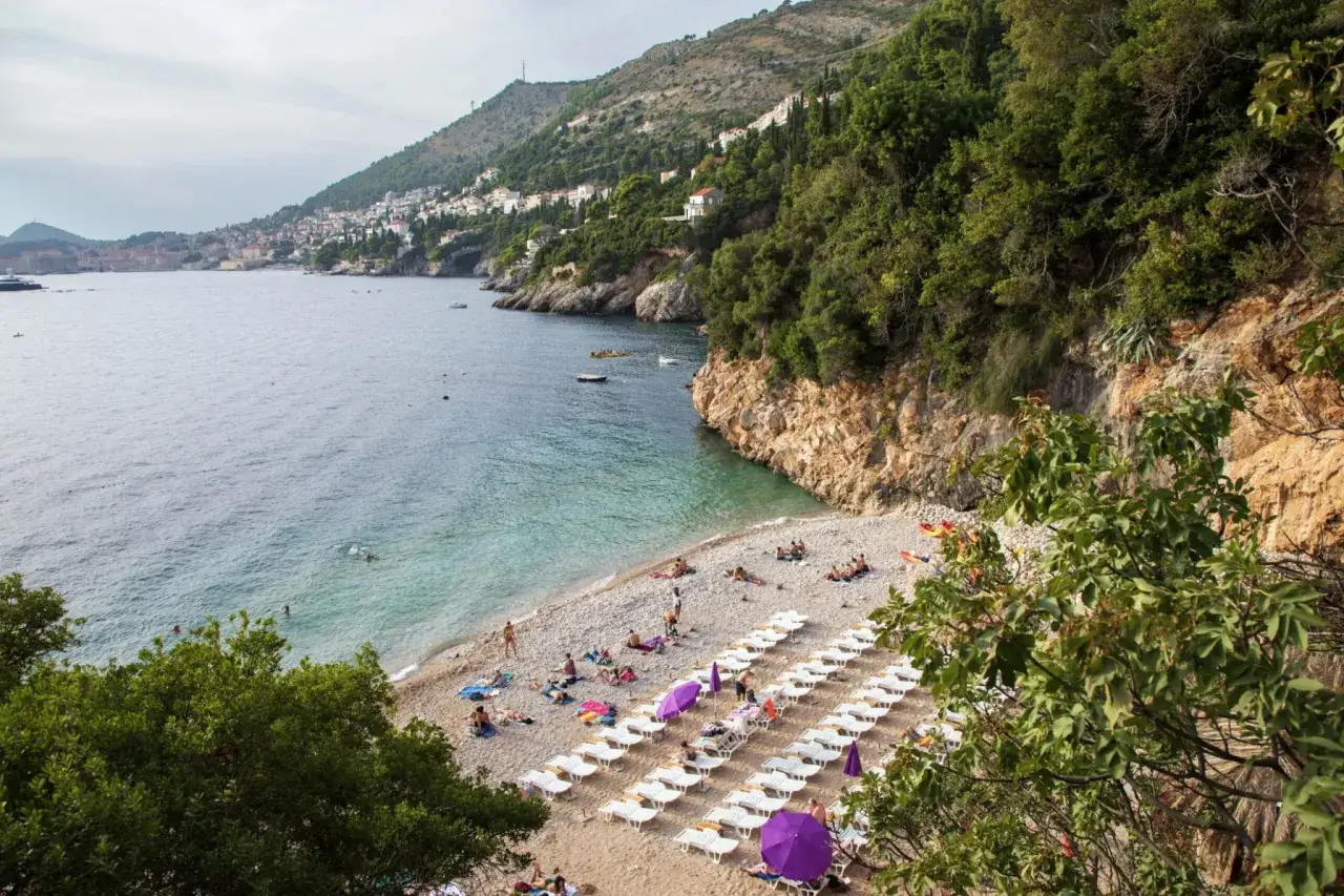 Piękna plaża w Chorwacji, idealne miejsce na wakacje. Woda kusi do kąpieli, a leżaki czekają na plażowiczów.