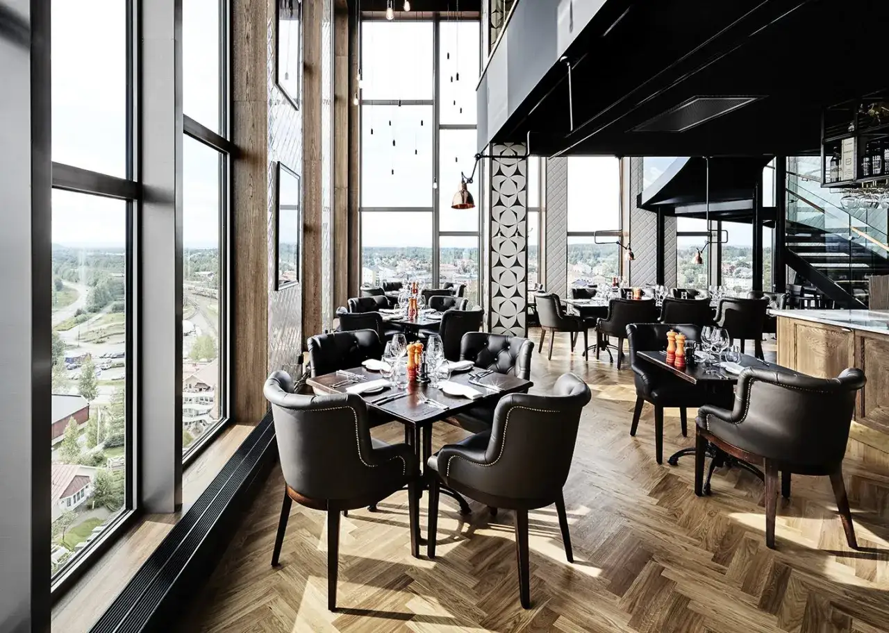 Elegant restaurang med stora f&ouml;nster och utsikt, perfekt f&ouml;r en middag p&aring; hotell Kust.