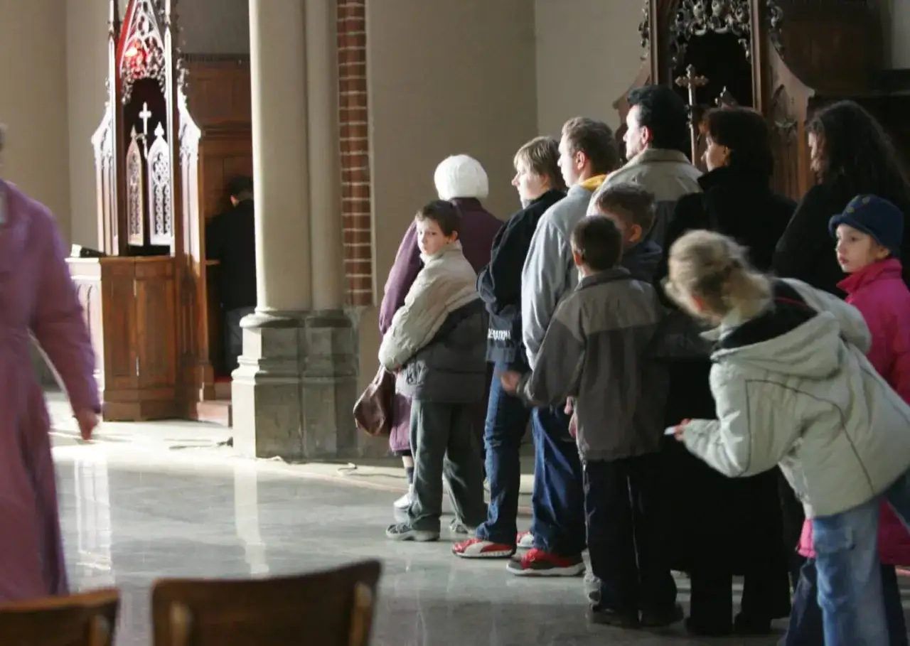 Dzieci i dorośli stoją w kolejce do konfesjonału. To może być czas na rachunek sumienia dla dzieci.