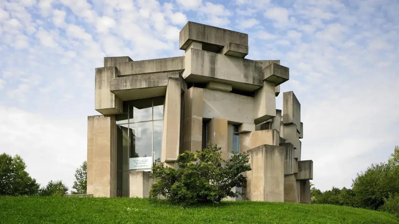 Ein markantes Beispiel brutalismus architektur: ein Betonbau mit geometrischen Formen, der sich gegen einen bew&ouml;lkten Himmel abhebt.