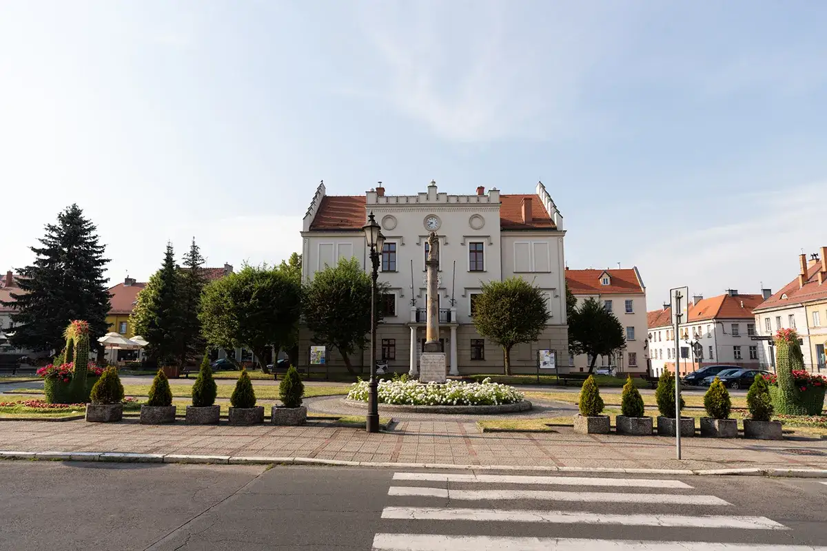 Rynek w Pyskowicach z ratuszem i pomnikiem. Wok&oacute;ł zadbane klomby i drzewka, tworzące urokliwe pyskowice atrakcje.