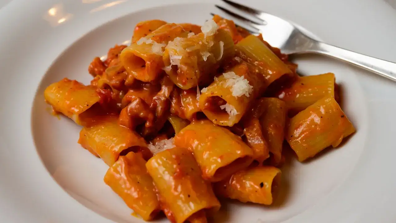 Rigatoni conditi con un sugo cremoso e saporito, un vero piatto di pasta alla zozzona, spolverati con parmigiano.