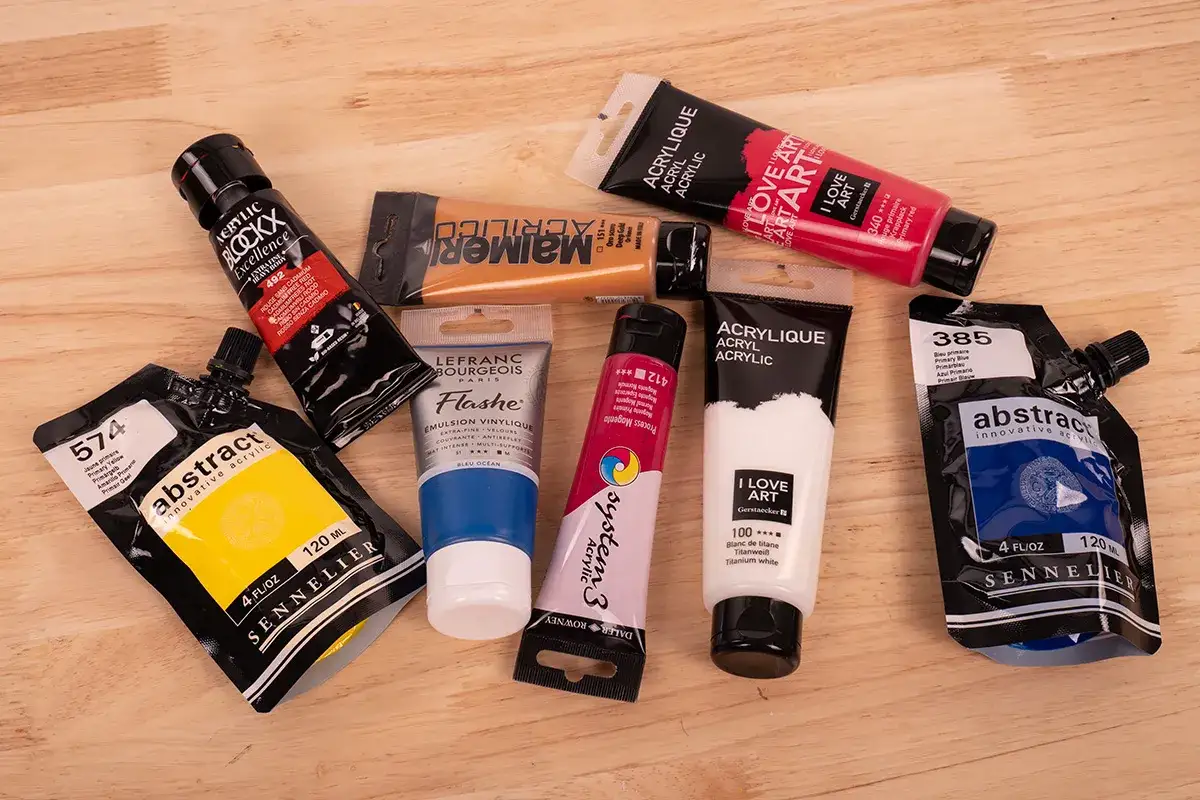 Un assortiment de tubes et pochettes de peinture acrylique, offrant une palette de couleurs vives pour une peinture à l'huile facile.