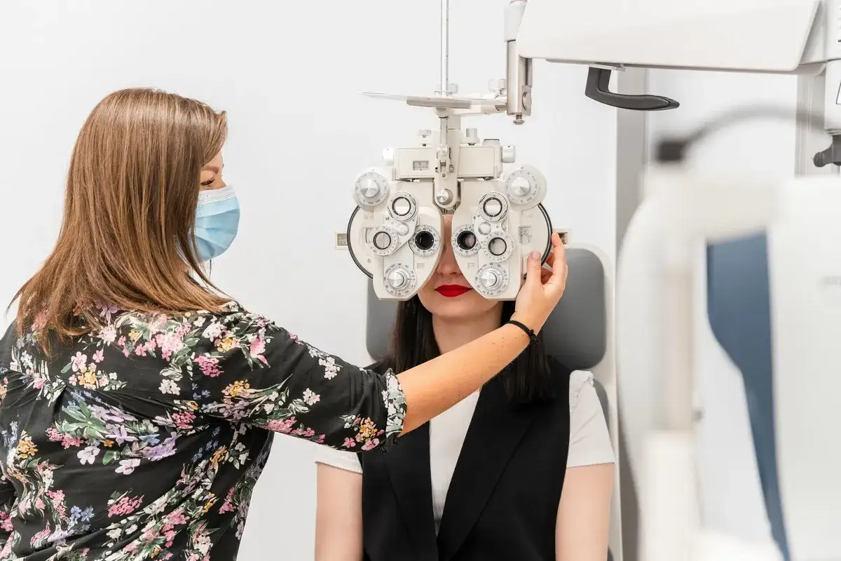 Okulary do dali co to znaczy? Optometrysta bada wzrok pacjentki za pomocą foroptera, urządzenia do testowania widzenia.