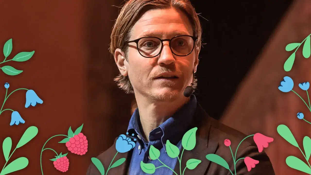 Alexander Lydecker med glas&ouml;gon och bl&aring; skjorta, omgiven av blommor och hallon.
