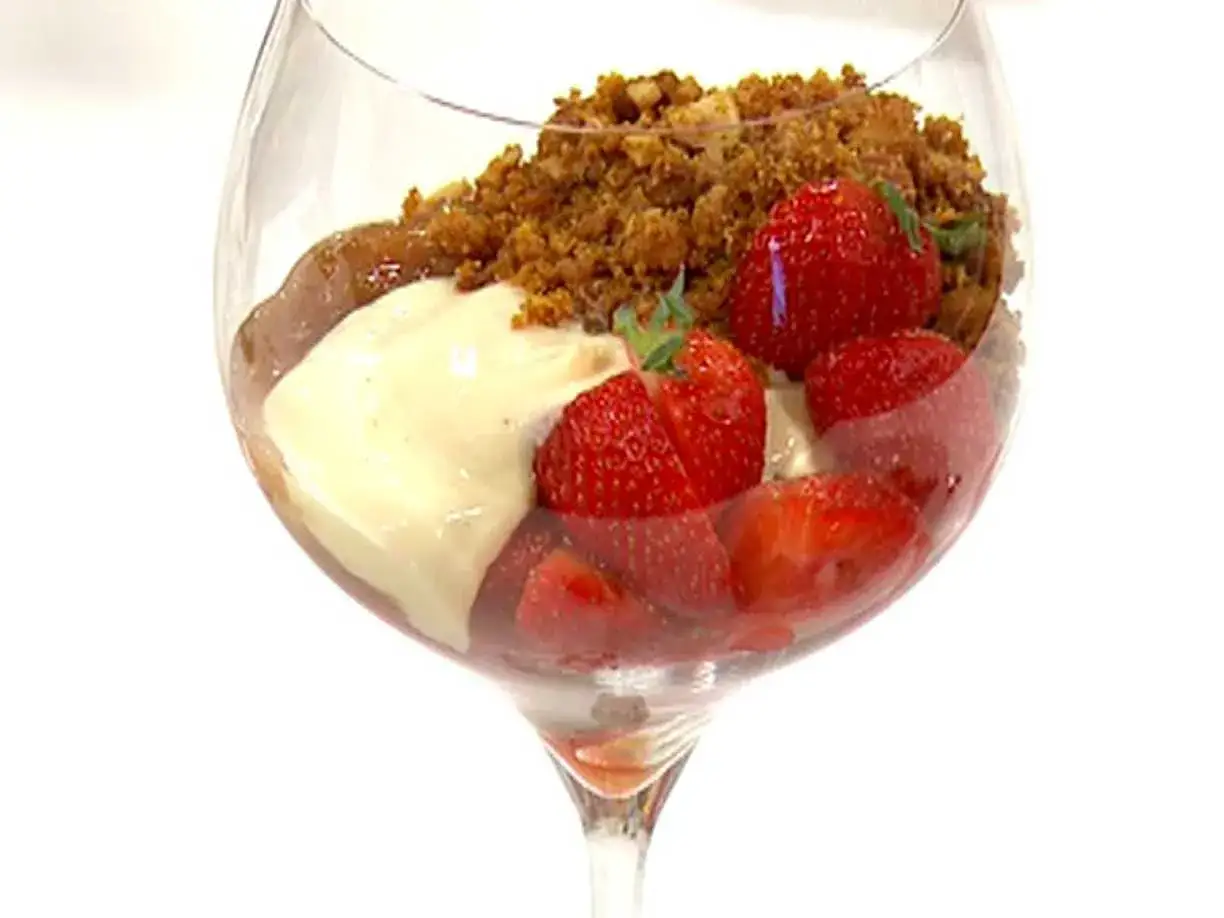 En dessert i glas med jordgubbar, vaniljkr&auml;m och smulig topping. Ett enkelt rabarberkompott recept som passar perfekt till.