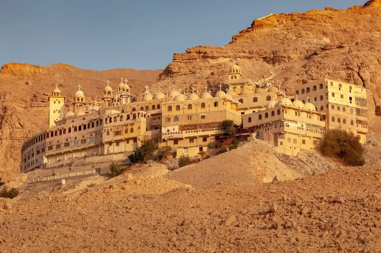 A sprawling monastery complex built into a rocky mountainside, its domes and crosses hinting at centuries of monk history.