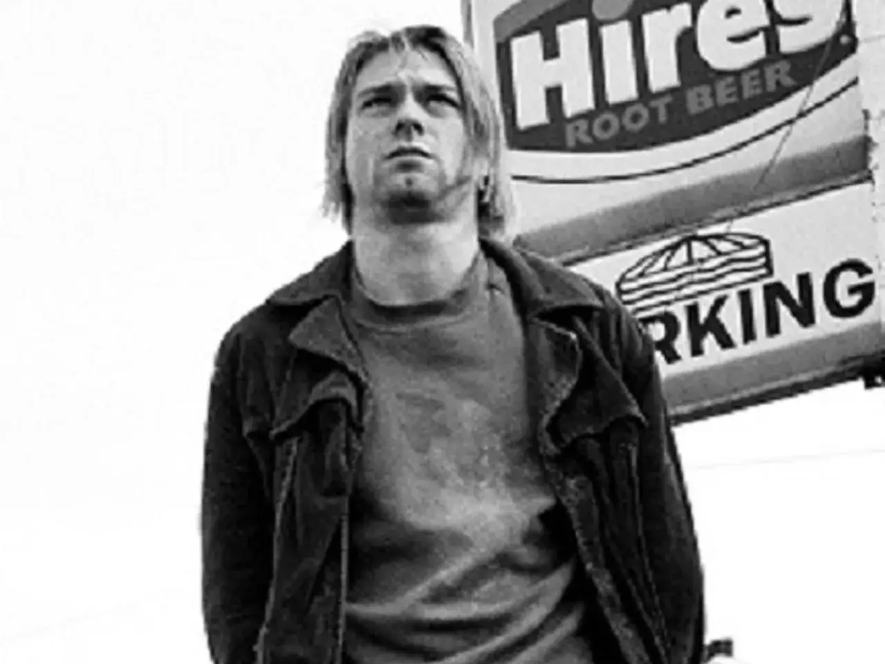 Kurt Cobain, ikona grunge, w dniu swojej tragicznej śmierci. W tle znak