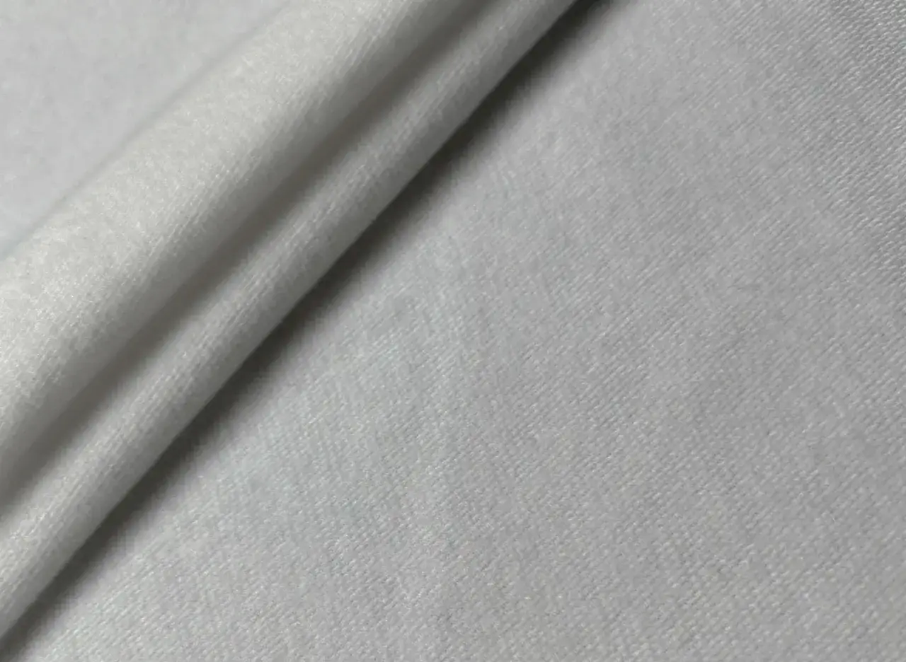 Wei&szlig;er, weicher Stoff, der die Frage beantwortet: ist Polyester warm? Ja, dieser Stoff f&uuml;hlt sich angenehm warm an.