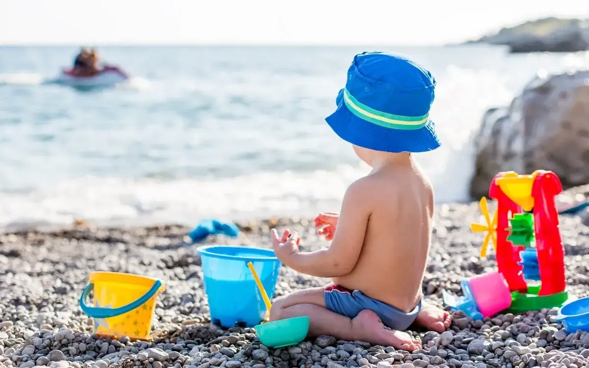 Dziecko bawi się na plaży z zabawkami