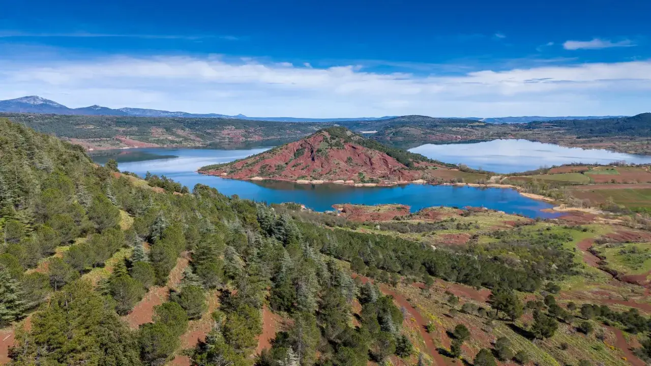 Vue a&eacute;rienne du lac du Salagou, id&eacute;al pour une randonn&eacute;e avec ses collines rouges et sa v&eacute;g&eacute;tation verdoyante.