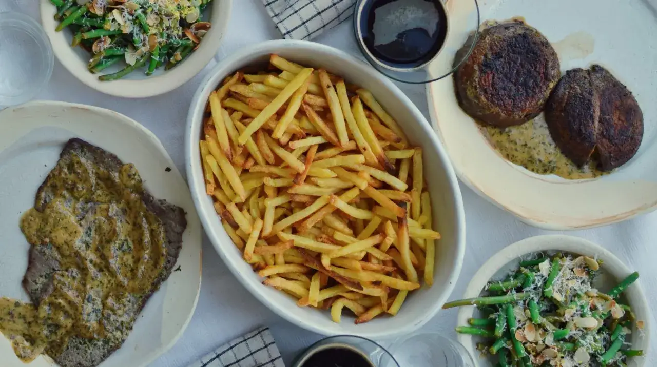 En skål med gyllene pommes frites, perfekt tillbehöret till den härliga måltiden med biff och gröna bönor.