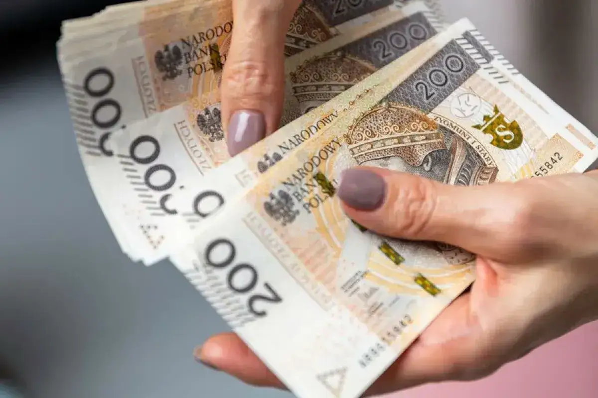 Dłonie trzymające stos banknotów 200 zł. Szybka pożyczka bez sprawdzania zdolności kredytowej to rozwiązanie dla Ciebie.