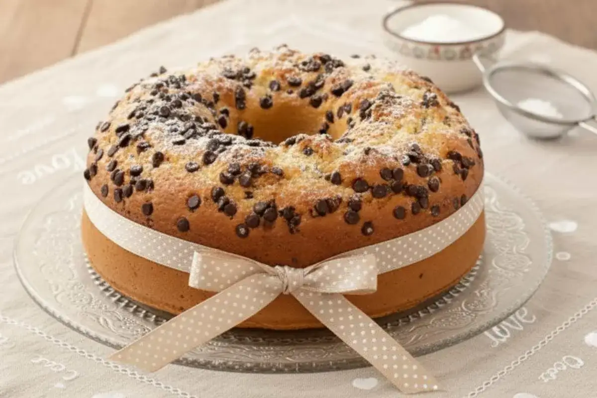 Ciambellone al bicchiere con gocce di cioccolato, spolverato di zucchero a velo e legato con un nastro a pois.