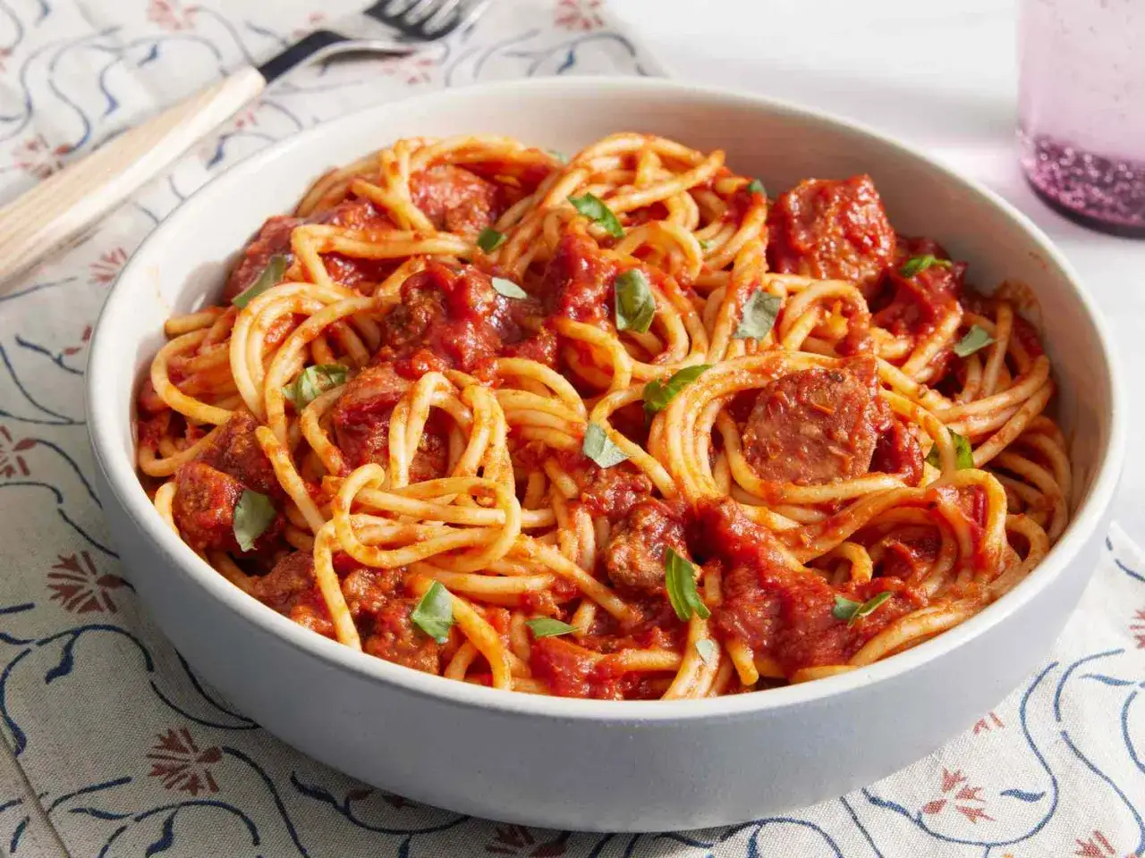 Miseczka spaghetti z bogatym, mięsnym sosem do spaghetti i listkami bazylii.