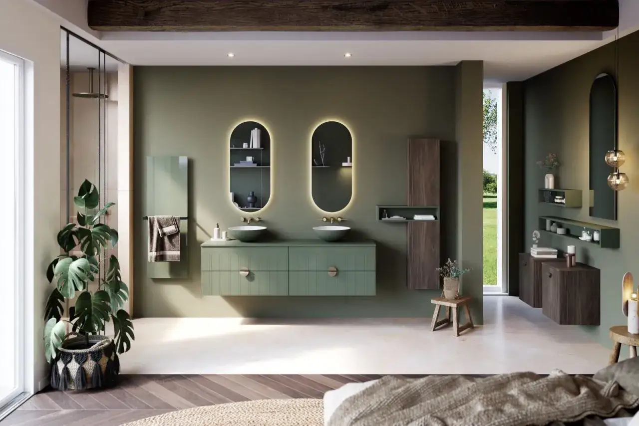Salle de bain moderne avec double vasque verte, miroirs ovales lumineux et murs vert sauge. Une belle idée couleur salle de bain pour une ambiance zen.