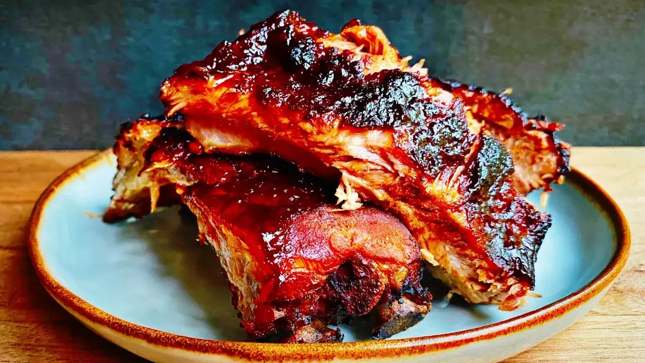 Soczyste żeberka w sosie BBQ, błyszczące od glazury, ułożone na talerzu. Idealne na letniego grilla.