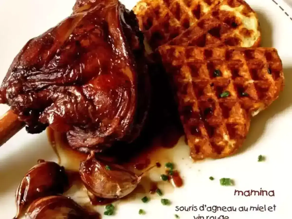 Souris d'agneau au miel et vin rouge, servie avec des gaufres croustillantes et des oignons caram&eacute;lis&eacute;s. Un plat savoureux et r&eacute;confortant.