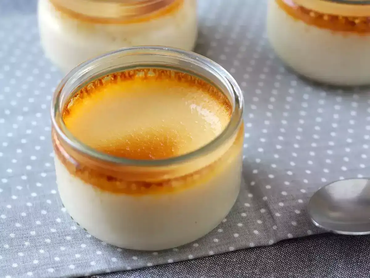 Trois pots de cr&egrave;me aux &oelig;ufs, avec une cro&ucirc;te caram&eacute;lis&eacute;e dor&eacute;e, sur une serviette &agrave; pois.