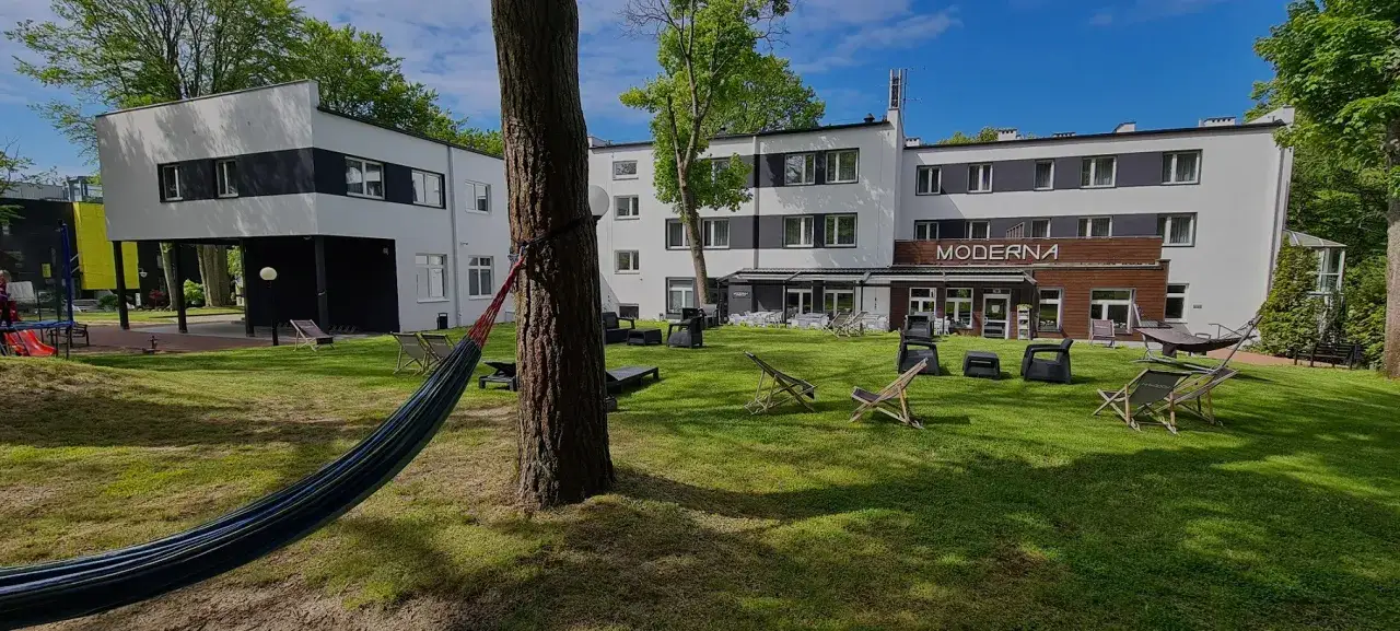 Relaks w moderna jastrzębia góra: leżaki, hamak i nowoczesna architektura na zielonym trawniku.