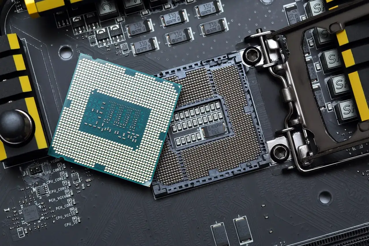 Porównanie procesorów w laptopach: jeden CPU leży obok gniazda na płycie głównej, gotowy do montażu.