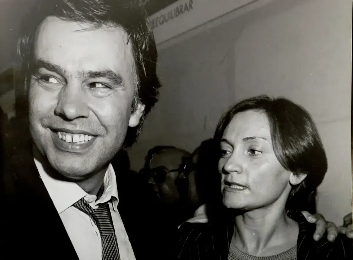 Gonzalo Mir&oacute; padre, sonriendo, junto a una mujer. Detr&aacute;s, otras personas.