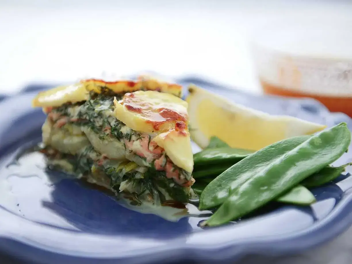Laxpudding med gravad lax, potatis och dill. Serveras med socker&auml;rtor och citronklyfta.