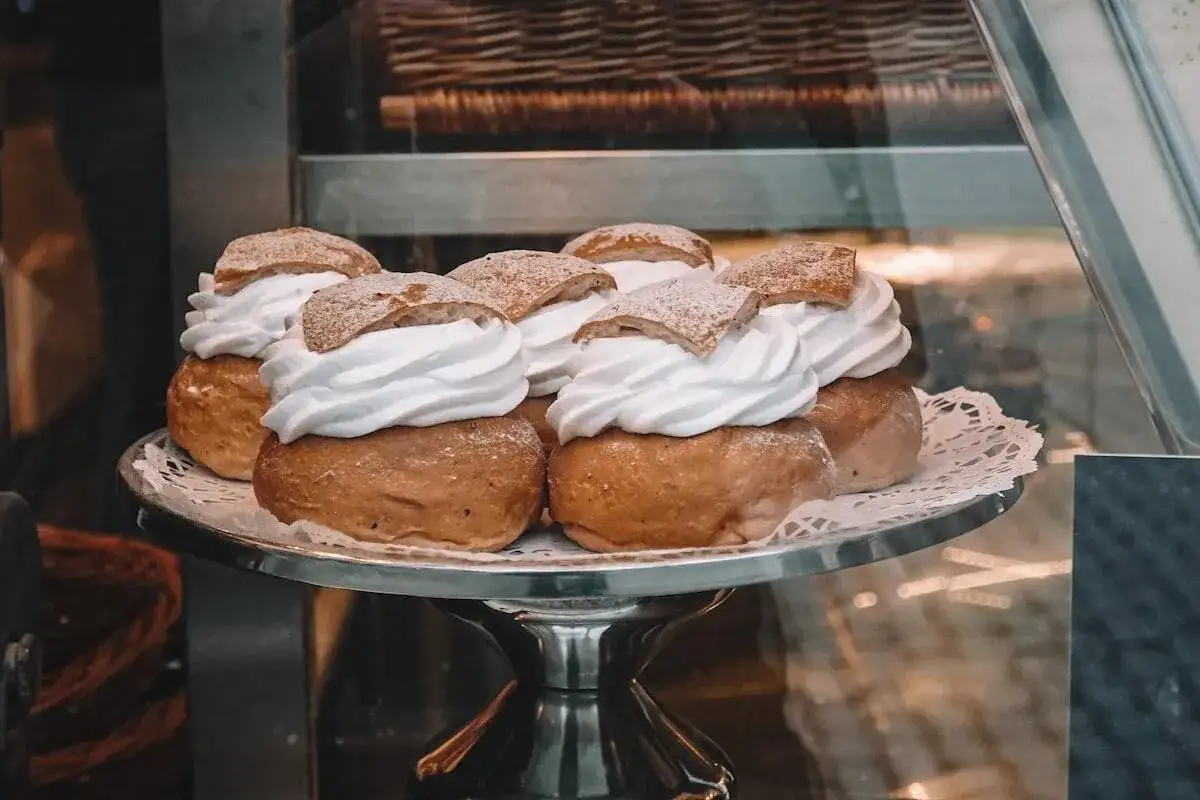 En bricka med flera semlor, redo f&ouml;r semlor dagen. Kr&auml;mig gr&auml;dde och pudrat florsocker.