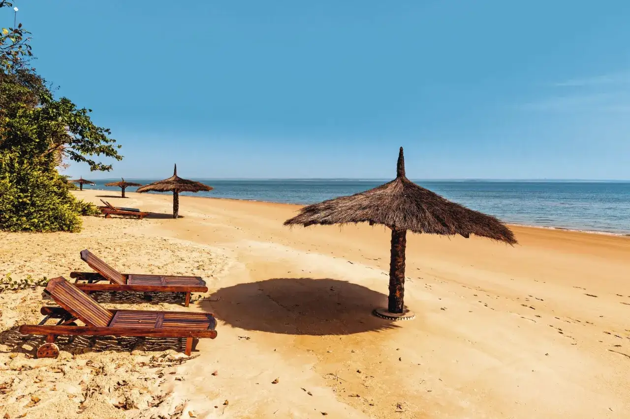 Pusta plaża w Gambii, z leżakami i parasolami. Idealne miejsce na relaks. Kiedy jechać? Najlepiej w porze suchej, od listopada do maja.