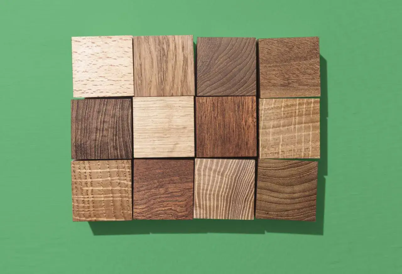 A grid of 12 wooden squares on a green background. Some woods have prominent grain, others are lighter. What wood is similar to acacia?