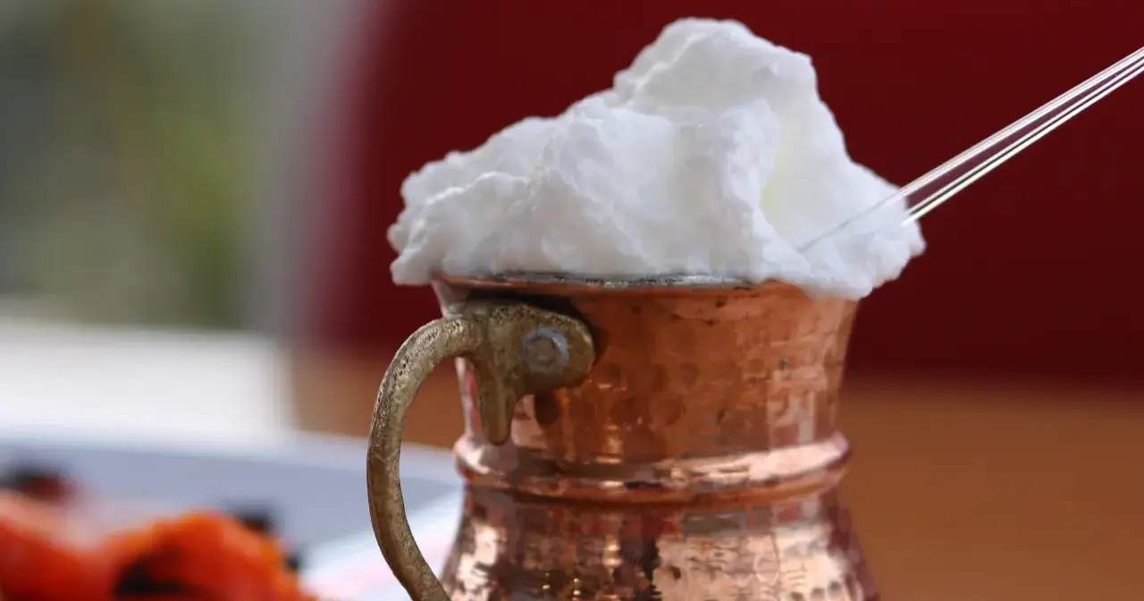 Puszysty ayran w miedzianym kubku, idealny na upały. Czy ayran jest zdrowy? Tak, to nap&oacute;j probiotyczny.