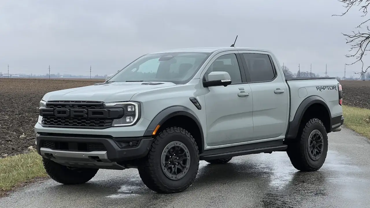 Szary Ford Ranger Raptor stoi na mokrej drodze, gotowy na przygodę.