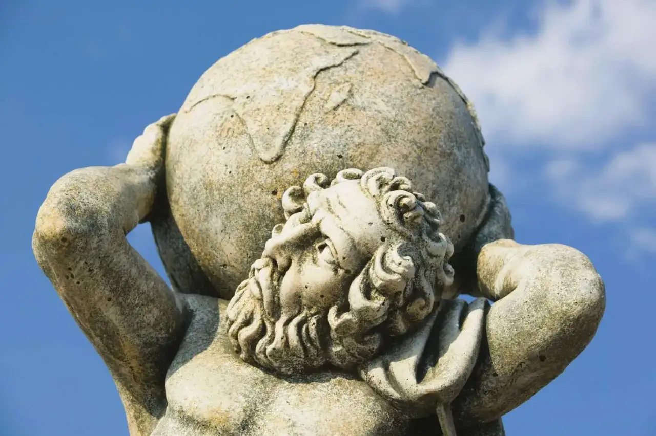 Stone statue of Atlas, punished to hold the heavens for eternity. His face strains under the weight of the world.